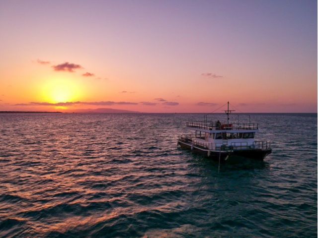 石垣島の夕日をバックに航行するサンセットクルーズBBQの船