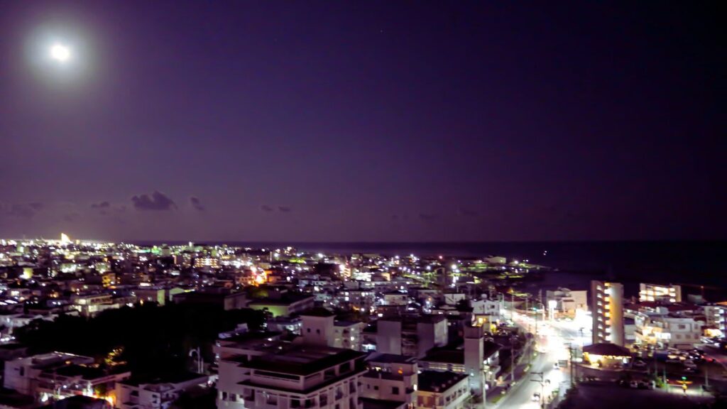 月明かりの下、光り輝く石垣島の市街地の夜景