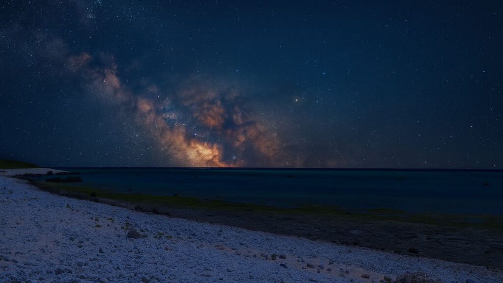 星空に包まれた白保海岸の夜景と静かな海面に映る天の川
